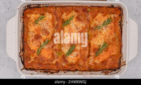 Close up view of fresh baked spinach lasagna with rosemary topping, flat lay Stock Photo