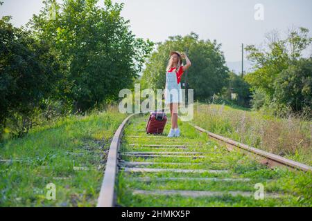 a man is walking on the railroad with a suitcase Stock Photo