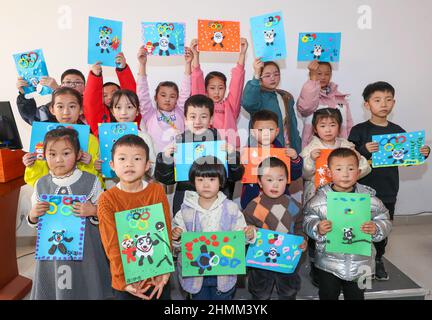 YUNCHENG, CHINA - FEBRUARY 10, 2022 - Children show 'Bing Dwen Dwen' and 'Xue Rong Rong' made of handmade clay in Yuncheng City, Shanxi Province, Chin Stock Photo