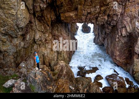 Tan Phung Fishing Village, Phu My, Binh Dinh, Vietnam - January 1, 2022: Tourists enjoy the experience at 'Mui Vi Rong' with a rock cave connecting to Stock Photo