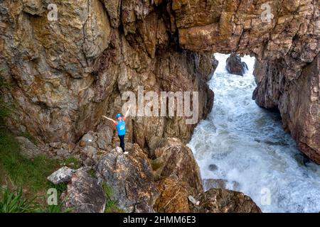 Tan Phung Fishing Village, Phu My, Binh Dinh, Vietnam - January 1, 2022: Tourists enjoy the experience at 'Mui Vi Rong' with a rock cave connecting to Stock Photo