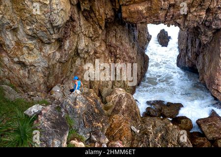 Tan Phung Fishing Village, Phu My, Binh Dinh, Vietnam - January 1, 2022: Tourists enjoy the experience at 'Mui Vi Rong' with a rock cave connecting to Stock Photo