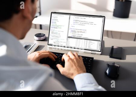 Computer Programmer Writing Program Code On Computer In Office Stock Photo