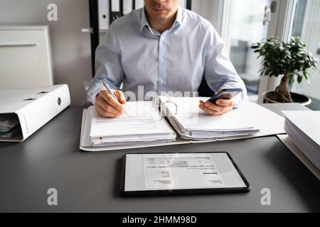 Accountant Using E Invoice Software At Tablet In Office Stock Photo