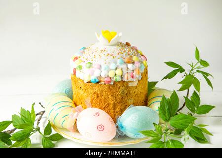 Easter cake with painted eggs on a platter in a gray interior. Traditional festive food Stock Photo