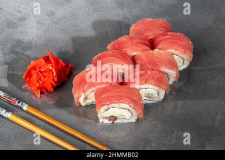 Sushi sets Uramaki, California, Philadelphia, rolls on a white plate. Menu for restaurants, cafes. On a dark reflective background. copy space Stock Photo