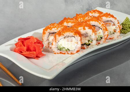 Sushi sets Uramaki, California, Philadelphia, rolls on a white plate. Menu for restaurants, cafes. On a dark reflective background. copy space Stock Photo