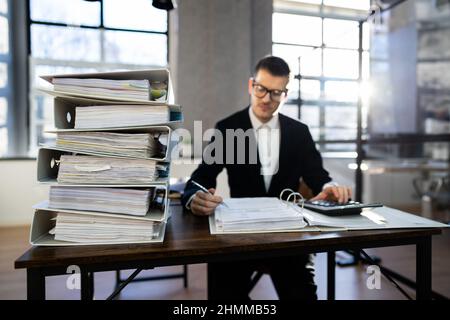 Accountant With Folders Paper Stack Doing Invoice Audit Stock Photo