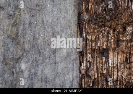 Old felt on dark wooden background. Dirty, stained woolen cloth. Cracked wooden surface with cracks and splinters. Top view. Selective focus. Stock Photo