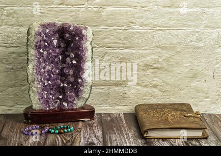 relaxing workstation with personal diary, amethyst geode and ethnic bracelets on wooden table. A relaxing environment in which to work, study or spend Stock Photo