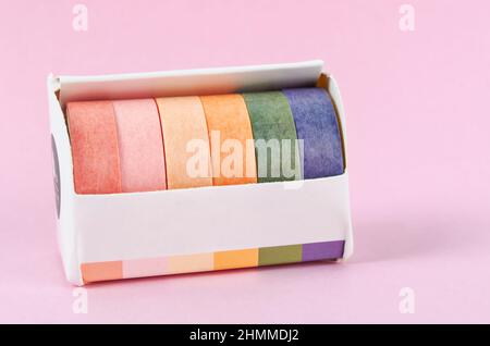 Collection of Colorful adhesive tape rolls in box on pink background. Stock Photo