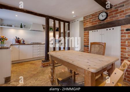 Great Chesterford, Essex - April 3 2017 - Kitchen and breakfast room within traditional cottage home with herringbone pattern brick floor, built in ap Stock Photo