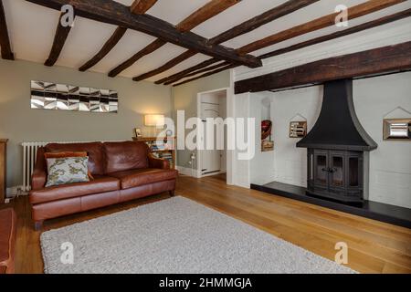Great Chesterford, Essex - April 3 2017 - Very stylish fashionably furnished and decorated old cottage living room with white painted fireplace Stock Photo