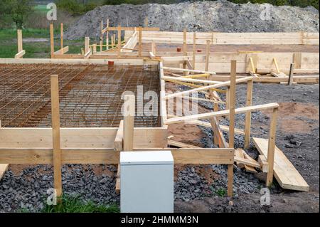 Construction of a residential house with an adjacent garage with the construction of a foundation and the associated formwork made of wood Stock Photo