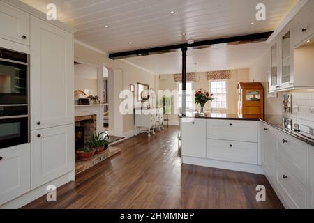 Hemingford Grey, Cambridgeshire - Feb 10 2018: Traditional styled luxury modern kitchen with fireplace and dining area in the background Stock Photo