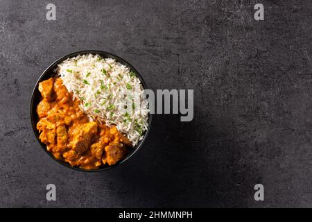 Indian butter chicken in black bowl on black background Stock Photo