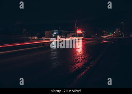Red and white lights from passing cars. Night highway. Stock Photo