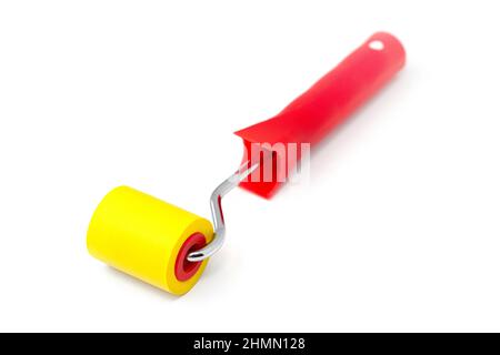 Yellow rubber paint roller on a white background. Stock Photo