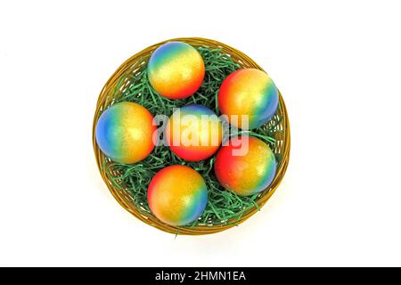 decorated brightly colored Easter eggs in a basket, view from above Stock Photo