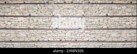 wild stone wall with wooden beams Stock Photo