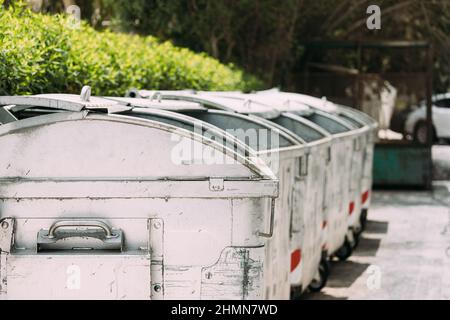 Waste containers on wheels for separate collection of garbage. Containers for temporarily storing waste. Dustbins, garbage cans, Trash cans on street Stock Photo