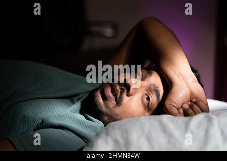 young man unable to sleep during night at bedroom - concept of suffering from insomnia, thoughtful and problems Stock Photo