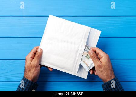 Male hands packing money in bubble envelopes for shipping. Stock Photo