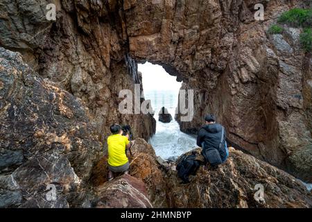 Tan Phung Fishing Village, Phu My, Binh Dinh, Vietnam - January 1, 2022: Tourists enjoy the experience at 'Mui Vi Rong' with a rock cave connecting to Stock Photo