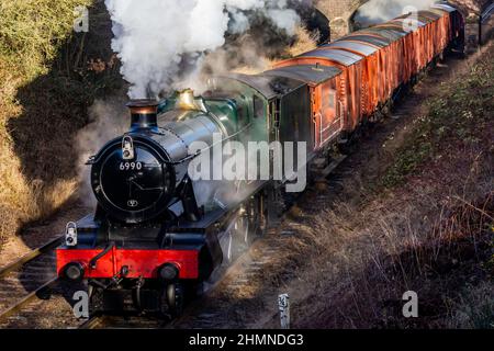 GWR locomotive 6990 Witherslack Hall with a goods train heading south on the Great Central Railway Stock Photo