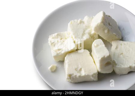 Plate of soft white cheese on white background - feta cubes Stock Photo