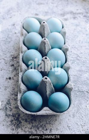Dyed blue Easter eggs painted with natural dye red cabbage on grey concrete background. Row of ombre blue Easter eggs. Natural ecological staining wit Stock Photo