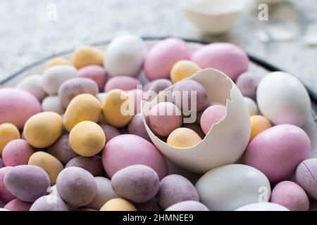 Easter composition with mini chocolate eggs in pastel colors on grey concrete background. Happy Easter Holidays. Stock Photo
