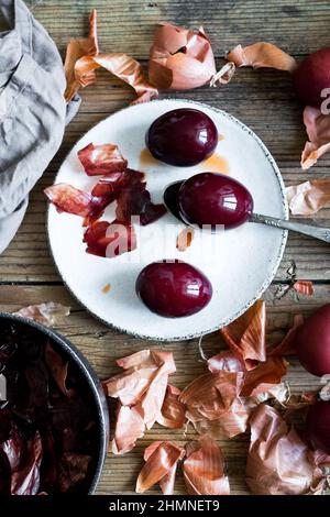 Dyed Easter eggs painted with natural dye onion on rustic wooden background. Process of dyeing eggs with natural paints for Easter. Natural ecological Stock Photo