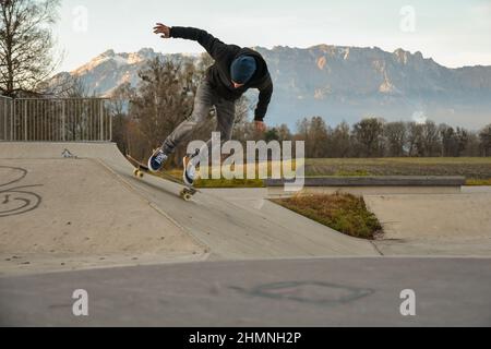 Vaduz, Liechtenstein, November 19, 2021 Guy on a skateboard is performing some cool moves Stock Photo