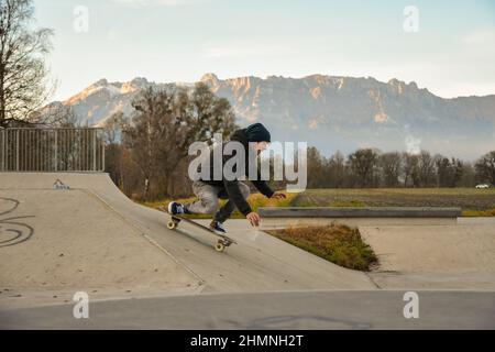 Vaduz, Liechtenstein, November 19, 2021 Guy on a skateboard is performing some cool moves Stock Photo