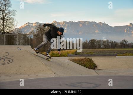 Vaduz, Liechtenstein, November 19, 2021 Guy on a skateboard is performing some cool moves Stock Photo