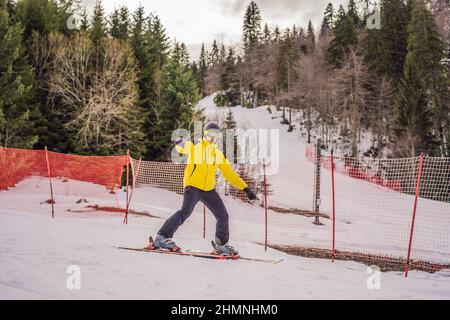 Ski instructor at training track showing students how to ski Stock Photo
