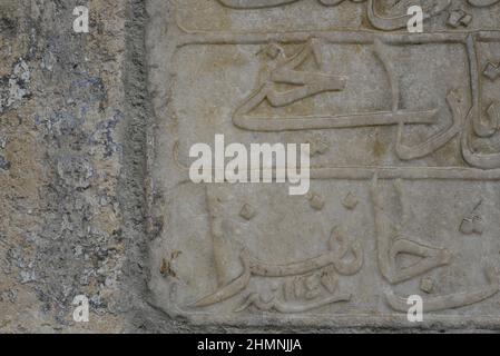 Ancient Islamic engravings on an aged marble plaque. Stock Photo