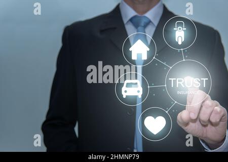 Businessman touching trust icon. Life, house, car and motorcicle Stock Photo