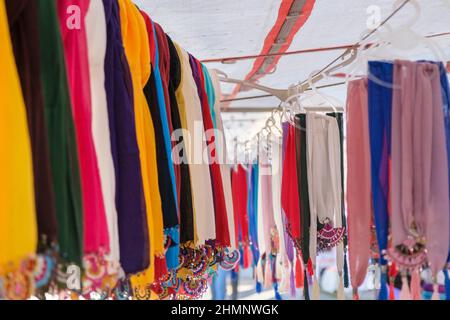Colorful handmade scarves lined up on a rope hanger in woman producer bazaar in Odemis, Izmir. Many or lots of different beautiful modern style needle Stock Photo
