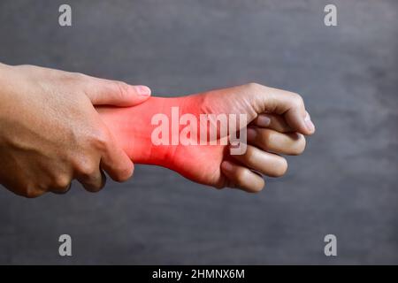 Inflammation of Asian young man wrist joint and hand. Concept of joint pain and hand problems. Stock Photo