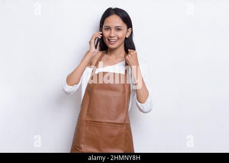 Young asian woman bartender or waitress using mobile smartphone isolated on white background Stock Photo