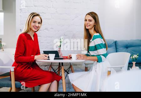 Cheerful female colleagues talking during coffee break Stock Photo