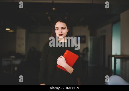 Charming woman with red notebook in cafe Stock Photo