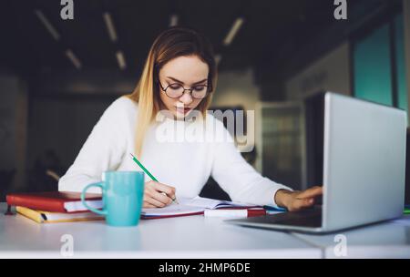 Young student doing homework using laptop Stock Photo