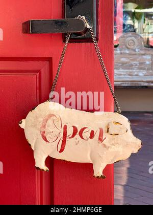 vintage pig shaped metal 'Open' sign hanging from door knob Stock Photo
