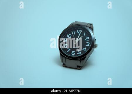 black wristwatch on blue background Stock Photo