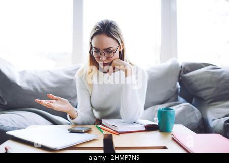 Confused young woman checking notifications on smartphone Stock Photo