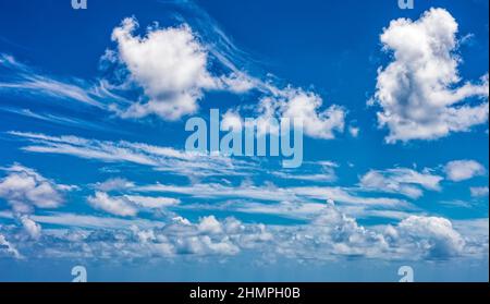Daytime blue sky Background with white cumulus clouds. Soft focus. Stock Photo