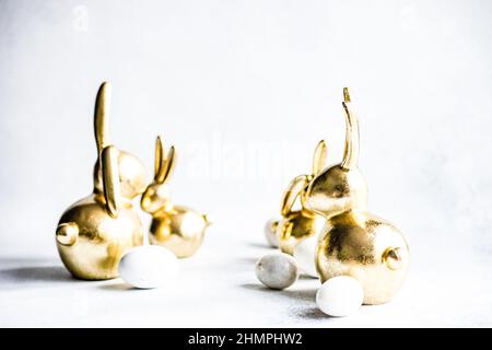 Golden Easter bunny decorations and Easter eggs on a table Stock Photo